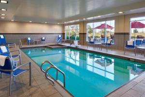 a pool in a hotel room with chairs and tables at TownePlace Suites by Marriott Thunder Bay in Thunder Bay