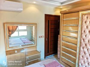 a dressing room with a mirror and a closet at A Wonderful Apartment in a compound in October Gardens in ‘Ezbet `Abd el-Ḥamîd