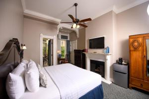 a bedroom with a white bed and a fireplace at Horton Grand Hotel in San Diego