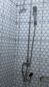 y baño con ducha y azulejos azules y blancos. en PEACE GUEST HOUSE en Yaundé