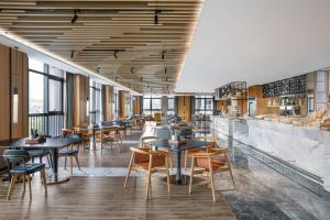 a restaurant with tables and chairs and a bar at Fairfield by Marriott Zhuhai Xiangzhou in Zhuhai