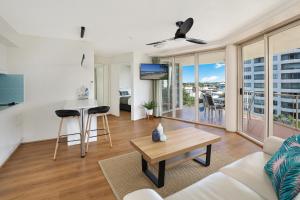 a living room with a couch and a table at Sandcastles Mooloolaba in Mooloolaba