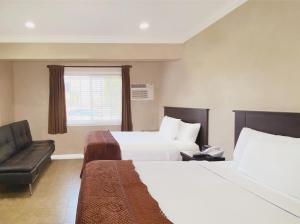 um quarto de hotel com duas camas e um sofá em Nite Inn at Universal City - Walking Distance to Universal Studios Hollywood em Los Angeles