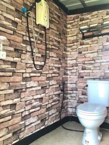 La salle de bains est pourvue d'un mur en pierre et de toilettes. dans l'établissement Chompunud House589 ชมพูนุชเฮ้าส์589, à Ban Don Klang