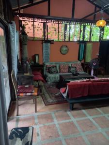 a living room with a bed and a couch at Teak house Chiang Mai in Chiang Mai