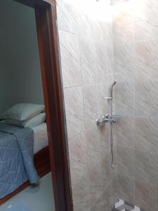 y baño con ducha y pared. en Chida Homestay, en Ubud