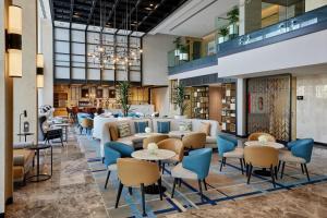 a lobby with tables and chairs and a library at Courtyard by Marriott Jubail in Al Jubail