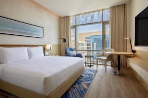 a hotel room with a bed and a large window at Courtyard by Marriott Jubail in Al Jubail