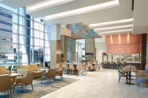 a restaurant with tables and chairs and windows at Lexington Marriott City Center in Lexington