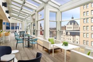 een grote kamer met tafels, stoelen en ramen bij Lexington Marriott City Center in Lexington