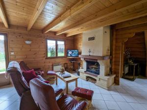 a living room with a fireplace in a log cabin at Gîte Vagney, 4 pièces, 6 personnes - FR-1-589-247 in Vagney