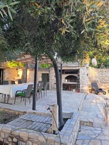 un patio con tavolo, sedie e un albero di Family friendly house with a swimming pool Benkovac, Zagora - 21720 a Benkovac (Bencovazzo)