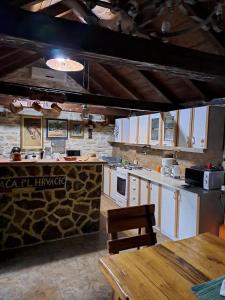una cucina con armadi bianchi e un muro in pietra di Family friendly house with a swimming pool Benkovac, Zagora - 21720 a Benkovac (Bencovazzo)