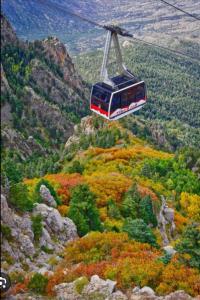 un teleférico volando sobre una montaña con follaje de otoño en 3Br 2Ba Charming gem near shops, restaurants, and hospitals en Albuquerque