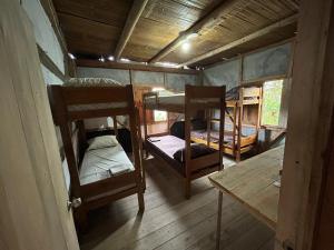 Habitación con 2 literas y mesa. en Hostal Camping Sin Fronteras Mompiche, en Mompiche