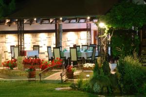 a patio with a table and chairs and flowers at Aleksandar Villa & Spa in Ohrid