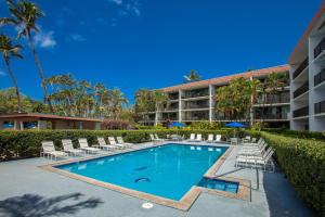 einen Pool vor einem Hotel mit Liegestühlen und einem Resort in der Unterkunft Maui Parkshore 105 - MCH in Kihei