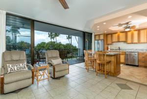 eine Küche und ein Wohnzimmer mit einem Tisch und Stühlen in der Unterkunft Maui Parkshore 312 - MCH in Kihei