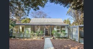 uma pequena casa verde com um caminho que leva até ela em Arohanui em Katoomba