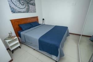 a bedroom with a bed with a blue comforter at Asuncion Apart - Villa Morra in Asuncion