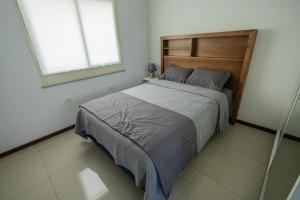 a bedroom with a bed with a wooden headboard and a window at Asuncion Apart - Villa Morra in Asuncion