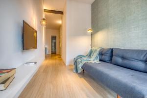 a living room with a blue couch and a television at Stay U-nique Apartments Rambla Catalunya III in Barcelona