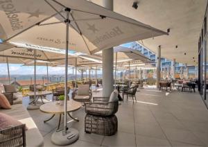 ein Restaurant mit Tischen, Stühlen und Sonnenschirmen in der Unterkunft Luxury Haven at Ellipse Waterfall in Midrand