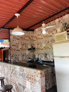 a kitchen with a counter with a tile wall at Casa de temporada Xerém in Duque de Caxias