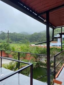 - une vue depuis le balcon d'une maison avec un étang dans l'établissement Casa de temporada Xerém, à Duque de Caxias