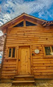 drewniany dom z drewnianymi drzwiami i oknami w obiekcie Mariposa - Cabañas Puerto del Zopilote w mieście Pinal de Amoles