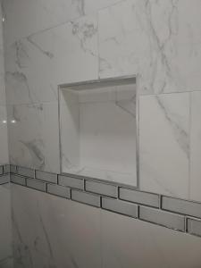 un bagno bianco con specchio a parete di Casa a Decatur