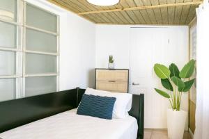 Un dormitorio con una cama en blanco y negro y una planta en Town Walk, Beach Steps, Sea View, en Enighed