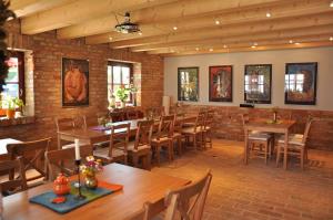 a restaurant with wooden tables and chairs and a brick wall at Café Landart im Thüringer Finistère in Plaue
