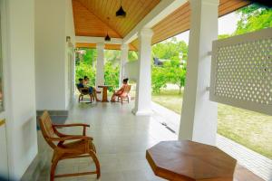two people sitting in chairs on the porch of a house at Serenity Villa Anuradhapura in Anuradhapura