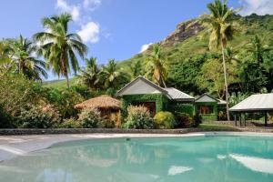 a house with a swimming pool in front of a mountain at Waya Island Resort in Yalombi
