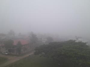 a foggy city with houses and trees on a street at Lucky Inn Coorg in Kushālnagar
