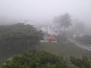 a house on top of a hill in the fog at Lucky Inn Coorg in Kushālnagar