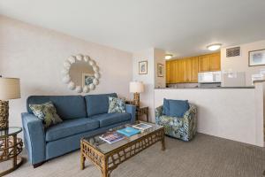 a living room with a blue couch and a table at Sugar Beach 522 - MCH in Kihei