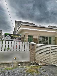 a white fence in front of a house at Wadihana Homestay in Kangar