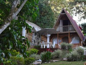 a cabin in the woods with a deck and chairs and an umbrella at ASGARD Spa in San Agustín
