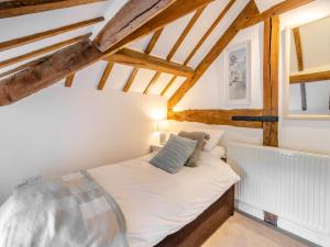 una camera con letto in una stanza con soffitti in legno di Walkers Retreat - Uk45415 a Eaton Bishop