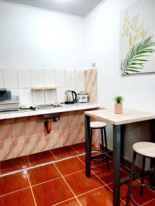 a kitchen with a counter and a table and stools at Studio type unit - Host Homes Apitong in Tacloban