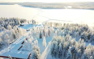 een luchtzicht op een bos met sneeuw bedekte bomen bij Palojärven Lomakeskus in Sonka