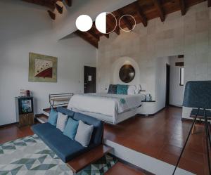 1 dormitorio con 1 cama y 1 sofá en Danzaluna Hotel Boutique en Valle de Bravo