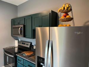 a kitchen with a stainless steel refrigerator with fruit on top at The Sahara #3 in Bellefontaine