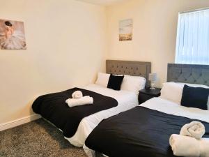 een slaapkamer met 2 bedden en handdoeken bij Luxury house for 6 guests next to Anfield stadium in Liverpool