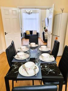 een eettafel met borden en bestek erop bij Luxury house for 6 guests next to Anfield stadium in Liverpool