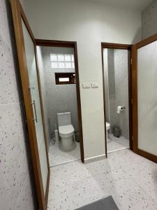 a bathroom with a toilet and a glass door at Blessings Home & Café in Haad Pleayleam