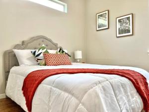 a bedroom with a bed with a red blanket on it at NEW! Luxury Apt, 5 min from Mall, Airport, & Dine! in McAllen