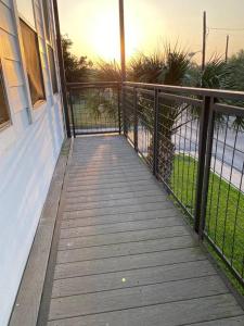 a wooden walkway leading to a house with a fence at NEW! Luxury Apt, 5 min from Mall, Airport, & Dine! in McAllen